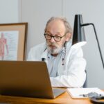 Photo by Tima Miroshnichenko: https://www.pexels.com/photo/an-elderly-man-in-white-lab-coat-talking-while-facing-the-laptop-8376291/